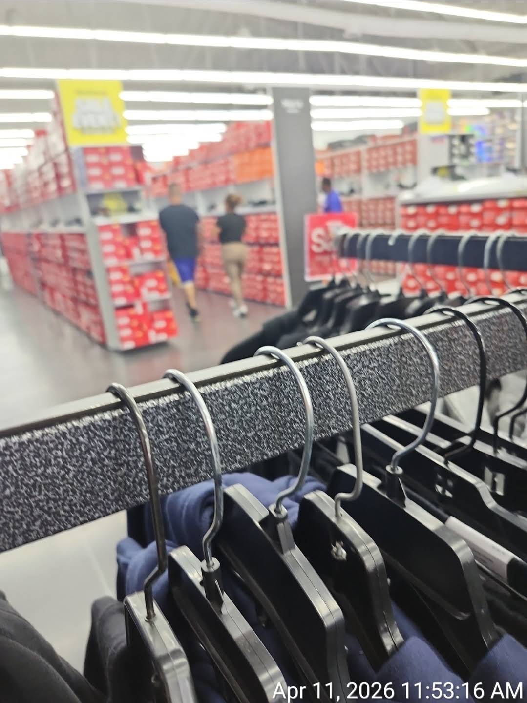 Clothing racks and a store aisle photographed from an observation viewpoint